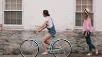 woman riding on teal cruiser bike near woman wearing pink long sleeved shirt