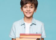 smiley-boy-holding-stack-books